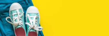 Kopyalama alanı ile sarı arka planda yeni turkuaz spor ayakkabılar.
