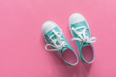 Kopyalama alanı ile pembe arka plan üzerinde yeni mavi spor ayakkabıları.