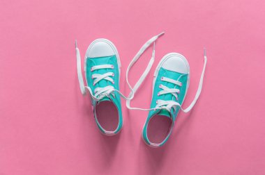 Kopyalama alanı ile pembe arka plan üzerinde yeni mavi spor ayakkabıları.