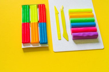 Kırtasiye düz yatıyordu. Plasticine gökkuşağı renk yığını ve plastik tahta. Okula geri dön.