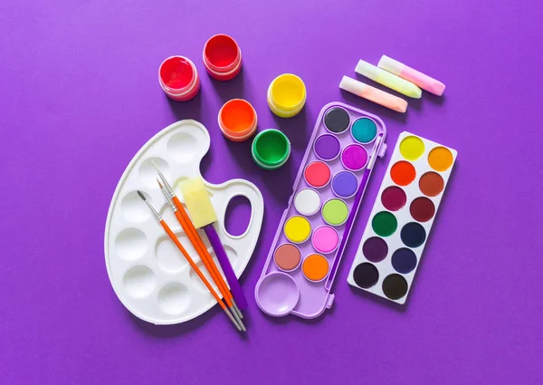 Stationery flat lay. Material for drawing and the artist lies on a Violet background. — Stock Photo, Image