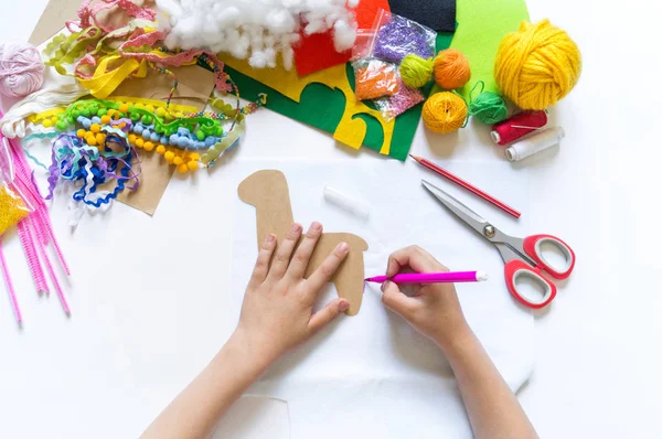 子供のDIYの手は、手工芸品のおもちゃのラマを行います。フェルトソフトクラフトマンシップ. — ストック写真