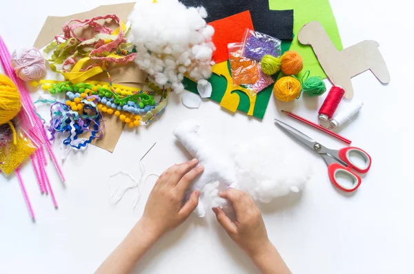 The hands of the child diy do handicraft toy lama. Felt soft craftsmanship. — Stock Photo, Image