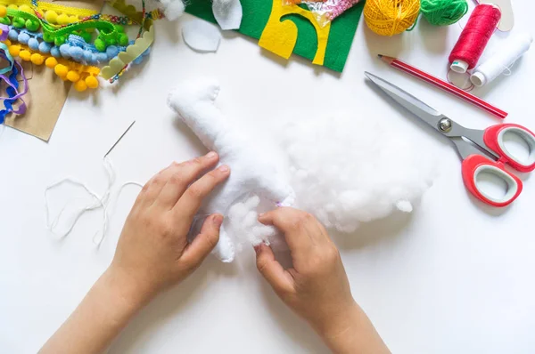 The hands of the child diy do handicraft toy lama. Felt soft craftsmanship. — Stock Photo, Image