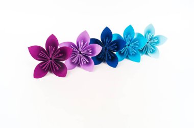 Origami kusudama çiçek beyaz bir arka plan karşı bir satır duruyor. Gökkuşağı rengi.