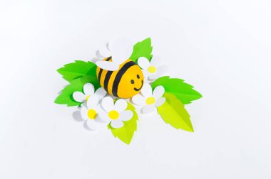 Tatil balı. Bir arı beyaz arka plan kesmek. El sanatları arı boyalı yumurta. Paskalya. Origami kağıt çiçek. Dıy