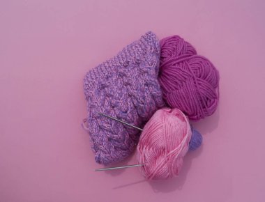 Bir leylak kap örme işlemi. Pembe arka planda yünlü iplikler. Rahat iplik.