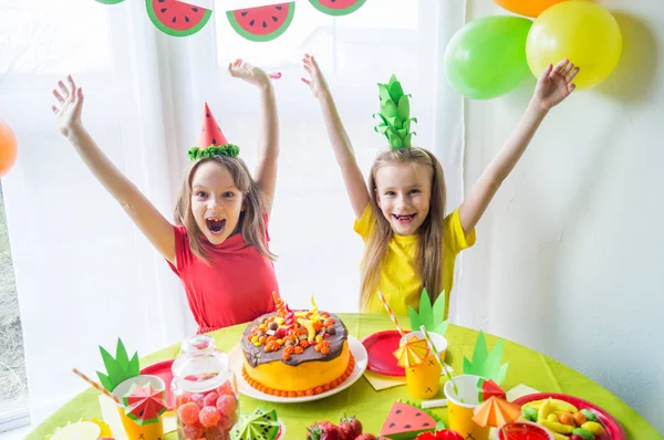 Dos chicas celebran su cumpleaños. Fiesta de frutas. Traje de piña y sandía. Vacaciones infantiles . —  Fotos de Stock