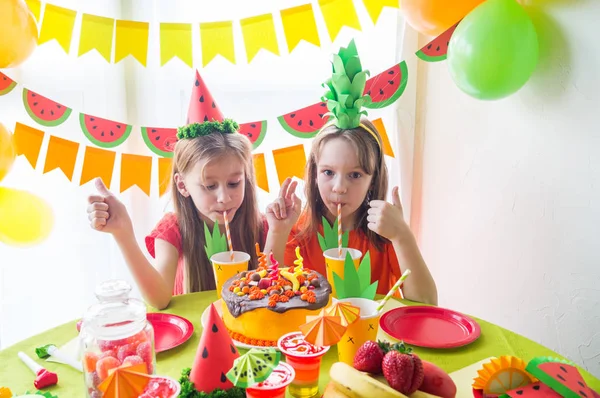 Dos chicas celebran su cumpleaños. Fiesta de frutas. Traje de piña y sandía. Vacaciones infantiles . —  Fotos de Stock