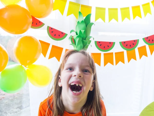 Los niños celebran un cumpleaños. La chica se ríe con un traje de piña. Fiesta de frutas . — Foto de Stock