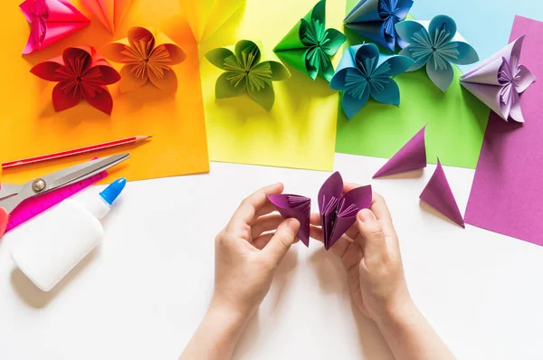 Kız origami Eller Violet trend renk kağıt çiçekler koyar. Origami dersi. Düz döşeme stili.