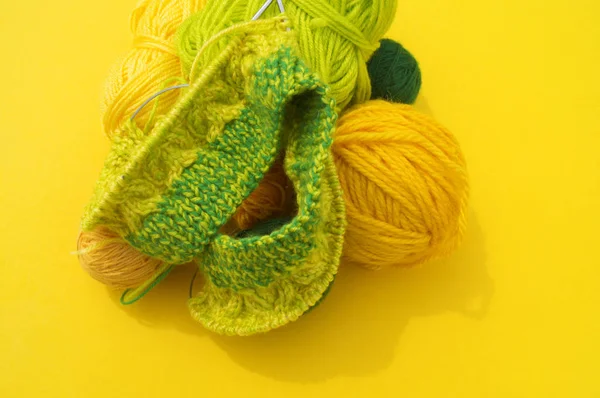 Gele en groene jassen van wol liggen op tafel. Favoriete hobby is breien. — Stockfoto