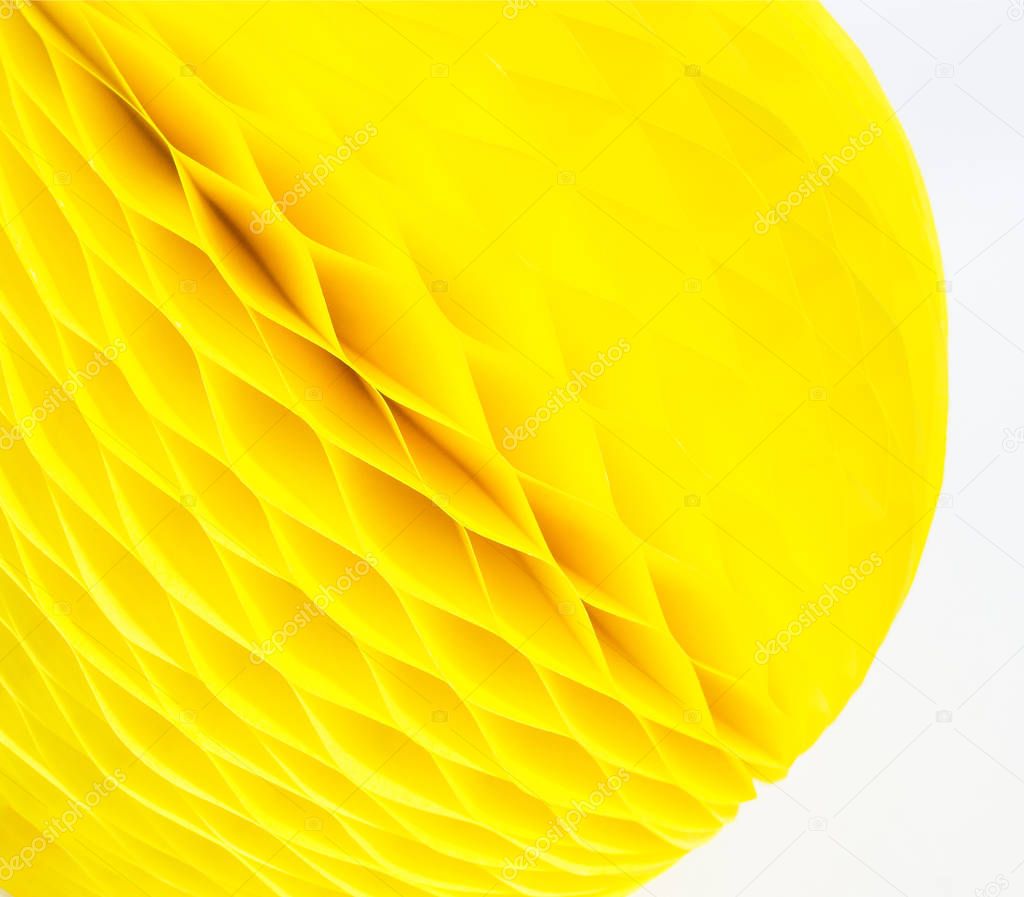 Yellow ball of paper honeycomb. White background. Paper craft.