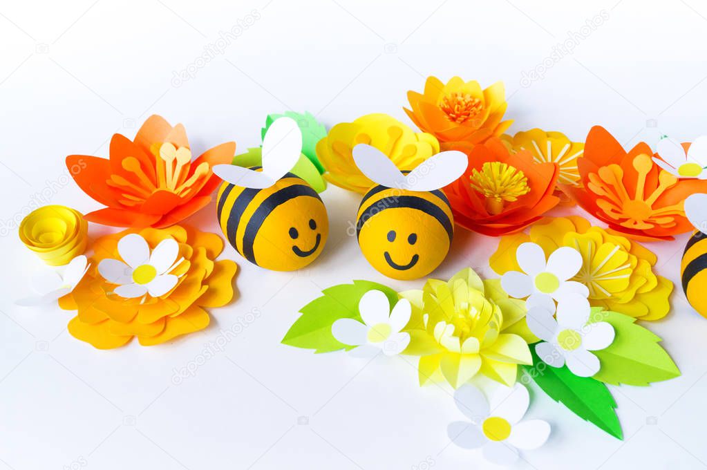 Holiday honey. white background. Handicraft bee painted egg. Easter. Origami paper flower. Diy