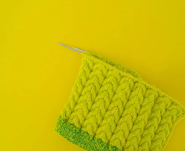 Casacos amarelos e verdes de lã jazem sobre a mesa . — Fotografia de Stock