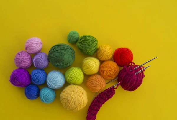 Bola para tricotar a cor do arco-íris um fundo amarelo . — Fotografia de Stock