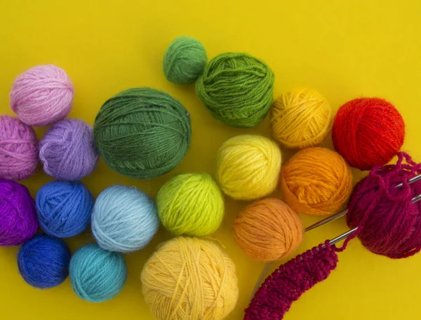 Bola para tricotar a cor do arco-íris um fundo amarelo . — Fotografia de Stock