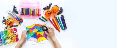 Çocuk gökkuşağı örümcek ağı çiziyor. Cadılar bayramı pastel boyaları pankartı çiziliyor