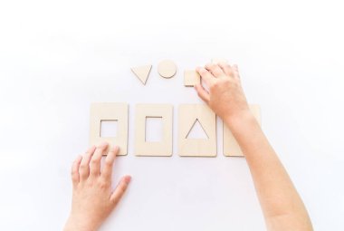 Montessori materyal matematik formu düz. Çocuklar el muamelesi görür. Beyaz arkaplanda tahta tepsi.