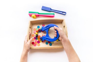 Montessori mıknatısı düz yerde yatıyordu. Çocuklar el muamelesi görür. Beyaz arkaplanda tahta tepsi.