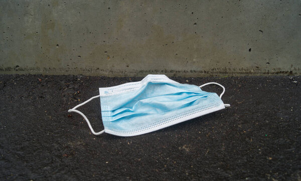 Mask is lying on the street. Garbage after coronavirus. Zero waste. Ecological lifestyle. Environmental pollution.