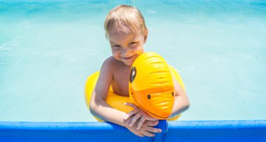 Hasır şapkalı lastik ördekli çocuk. Ahşap arka. Taze trend rengi. Havuz gezisi