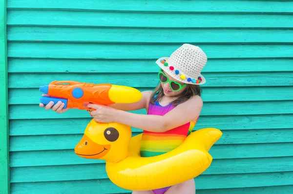 Uma Rapariga Com Uma Pistola Água Bebê Chapéu Óculos Fundo — Fotografia de Stock