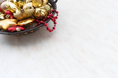 Yuvarlak bir sepetteki Noel süsleri. Altın kırmızı yıldız ve top