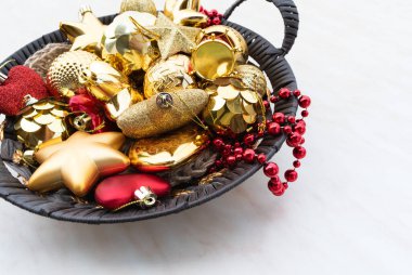 Yuvarlak bir sepetteki Noel süsleri. Altın kırmızı yıldız ve top