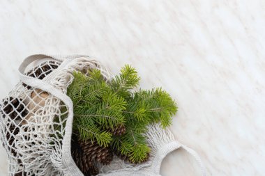 Sıfır Noel konsepti. Doğal Noel süslemeleri, çam kozalakları ve keten çantada dallar. Düz yatış, üst görünüm