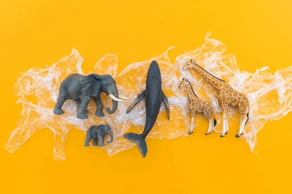 Animals is entangled in a plastic bag. Plastic animal concept. Yellow background. Environmental pollution problem.