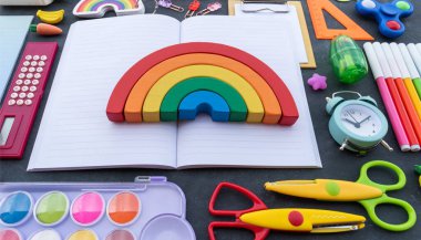 Kırtasiye tebeşiri. Okula dönelim. Ofis malzemelerinin üstüne not defterini aç. Okul için çocuk kawaii kırtasiyesi. Gökkuşağı oyuncağı