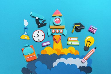 Roket kağıt işçiliğini çıkarıyor. Okula dönelim. Uzayı kopyala Mavi arka plan. Eğitim kavramı