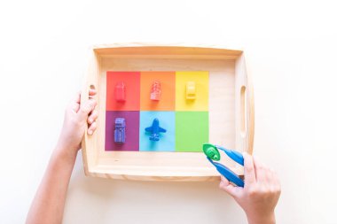 Montessori maddesi rengine göre sıralanıyor. Evde eğitim var. Çocuklu ders. Beyaz arkaplan.