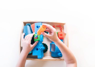 Montessori malzeme arabası. Evde eğitim var. İnşaatçıyı elle döndür. Çocuklu ders. Beyaz arkaplan.