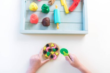 Montessori maddesi plastiktir. Şef eğitimi oyunu. Tahta tepside çocuk elleri. Beyaz arkaplan