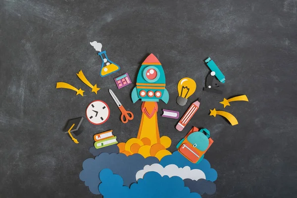Rocket takes off paper craft. Back to school. Copy space. Black background school board. Education concept