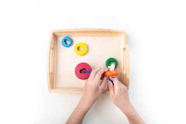 Montessori kumaşı. Bir çocuğun eli. Beyaz arka plan. Yeni yürümeye başlayan çocuk eğitimi. Matematik ve harf eğitimi. Okul ve anaokulu.