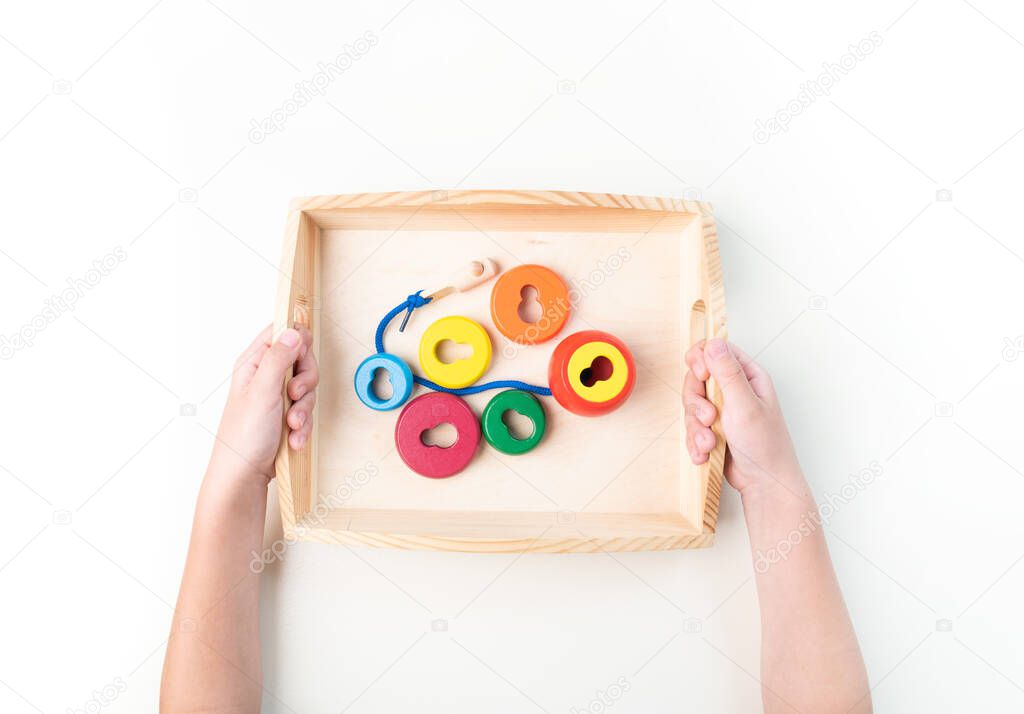 Montessori material. Hand of a child. White background. Toddler education. Study of mathematic and letter. School and kindergarten.