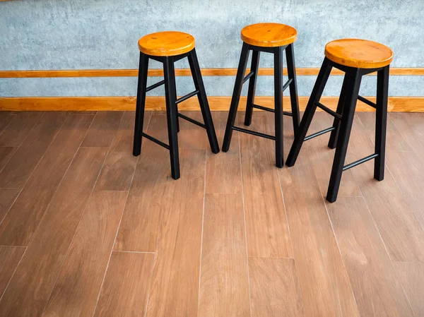 Simple wooden bar stools , 3 chair in group at indoor coffee bar.