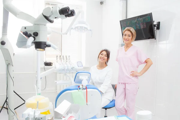 Dos chicas-dentistas jóvenes en la sala de tratamiento . — Foto de Stock