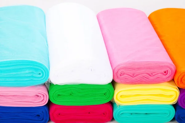 Multicolored fabric in rolls. Tulle. neatly stacked in a row — Stock Photo, Image