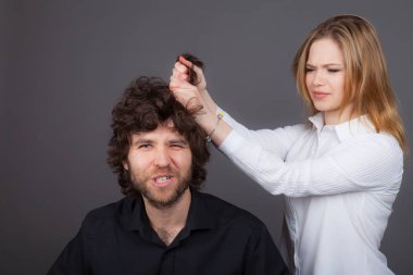 Genç bir kadın tarafından saç sakal kıvırcık saçlı bir adamla çekiyor. Fotoğraf stüdyosunda çekilmiş fotoğrafı