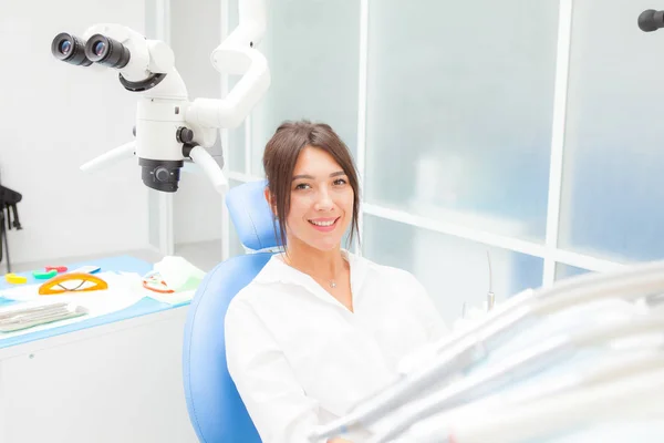 Mooi meisje in een tandheelkundige stoel lacht, kijken naar de camera — Stockfoto