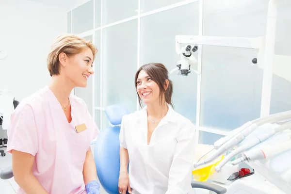 Niñas dentista y paciente en la habitación médica mirarse y sonreír —  Fotos de Stock