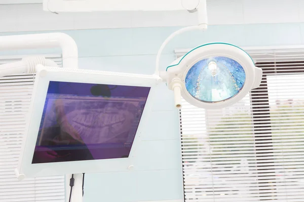 Lámpara quirúrgica en quirófano dental, monitor con rayos X de mandíbula — Foto de Stock