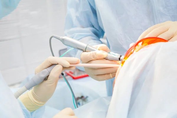 Zár-megjelöl folyamat férfi szakmai fogorvos sebész teljesítő művelet telepíteni fogászati implantátum fogak beteg ember Klinika. — Stock Fotó