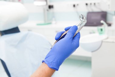 Diş dişçi, elinde kaldırılması için diş aracı 