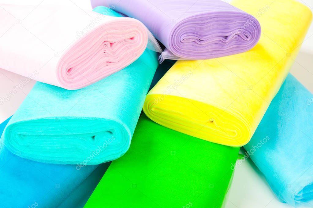 Rollos de tela de colores en el almacén - aislado sobre fondo blanco 2023