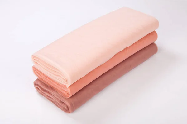 Rolos de tecido jazem sobre um fundo branco. gradiente bege — Fotografia de Stock